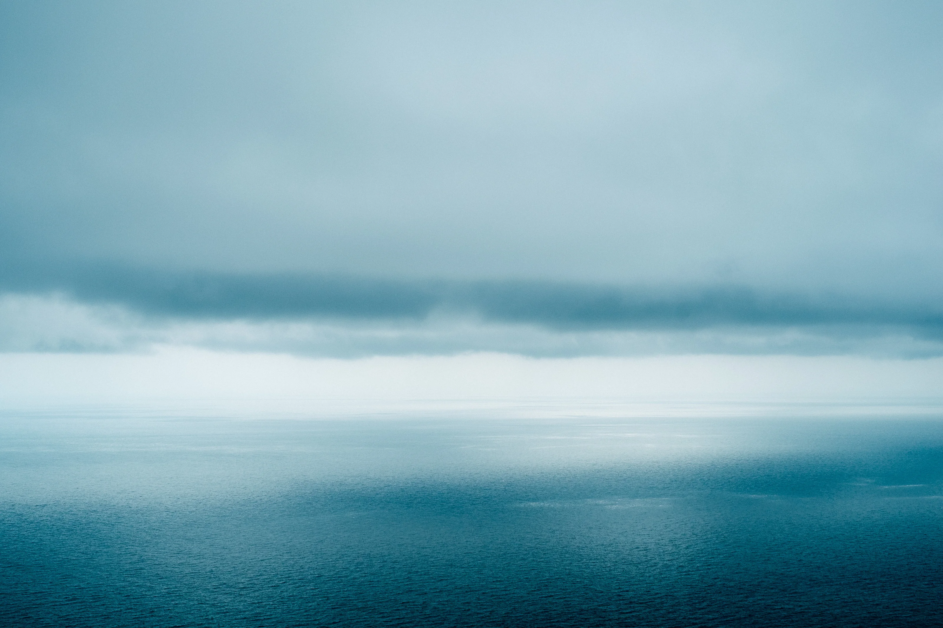 Calm ocean with a cloudy sky above.