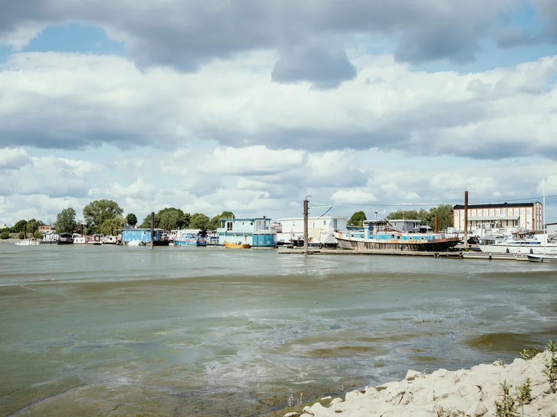 A small harbor with boats docked under a cloudy sky.