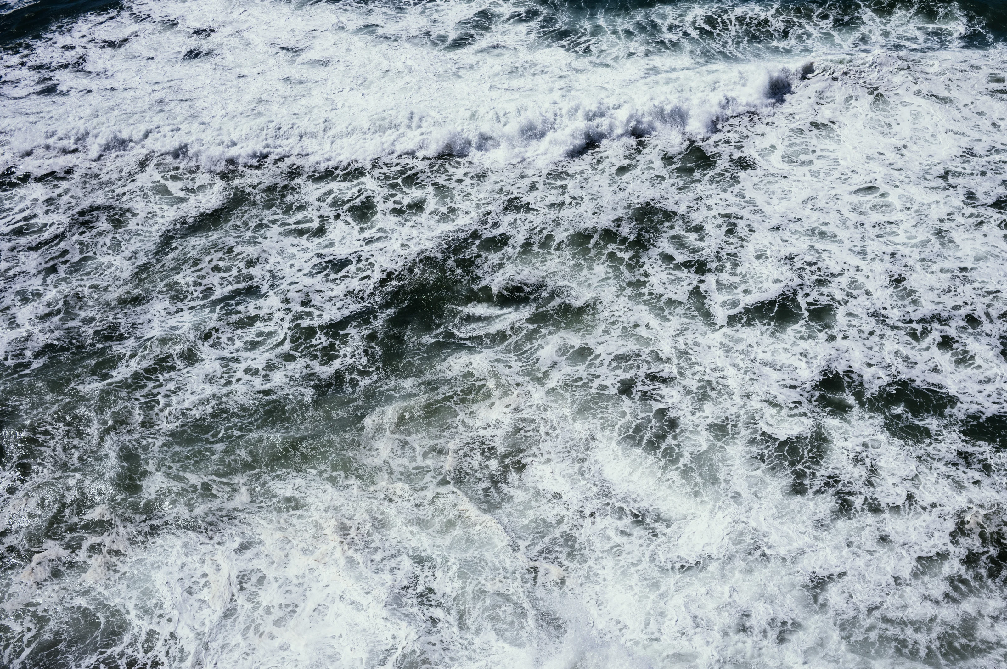 Waves crashing in the ocean with foamy water.